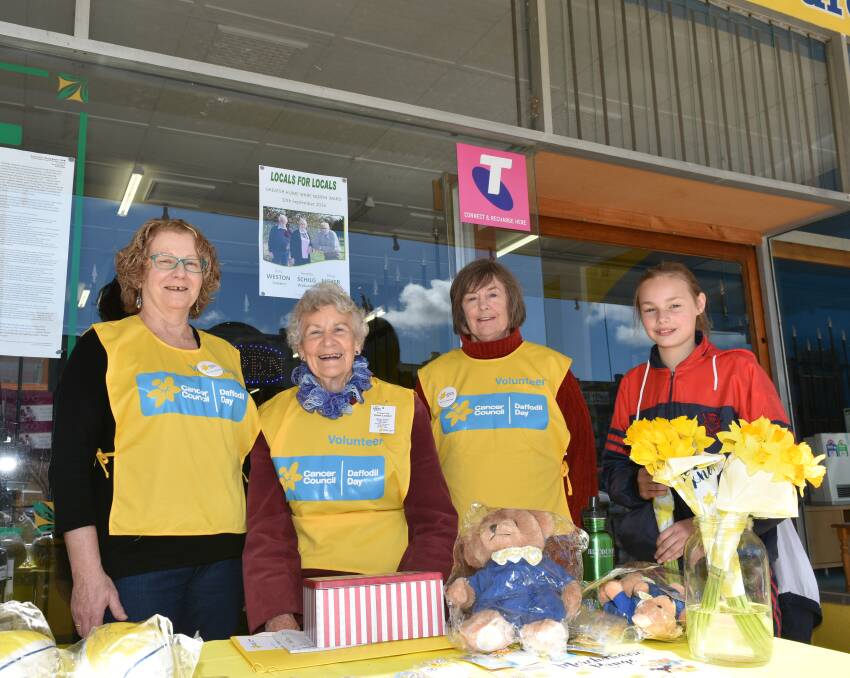 YELLOW: Terry Taylor, Ruth Kendall and Connie Ross were very pleased with sales of daffodils, with Anna Tofts getting one of the last bunches. The stall raised $526.