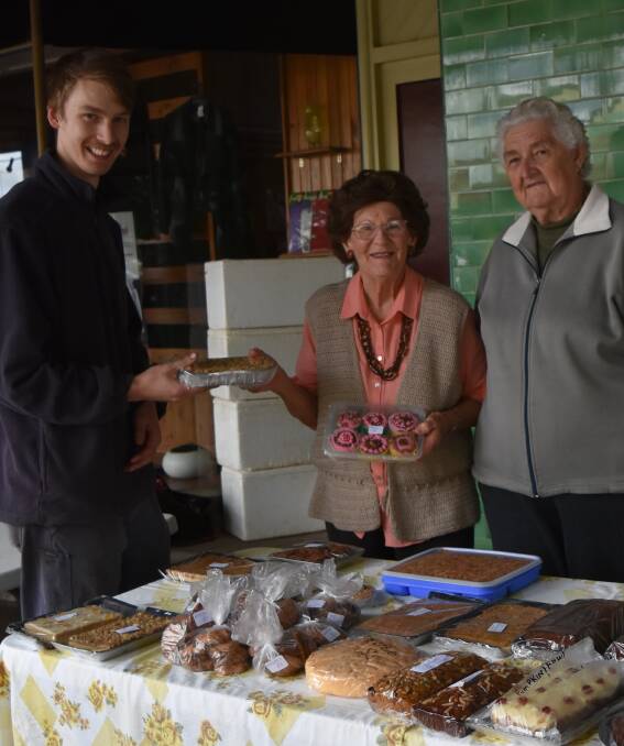 Dedicated: Nathan Klemke, Oriel McRae and Alice Hore. Oriel (centre) has been selling her cakes, jams and sauces in Henty for the past 17 years, with profit from the sales going to  World Vision. Picture: Lorri Roden. 