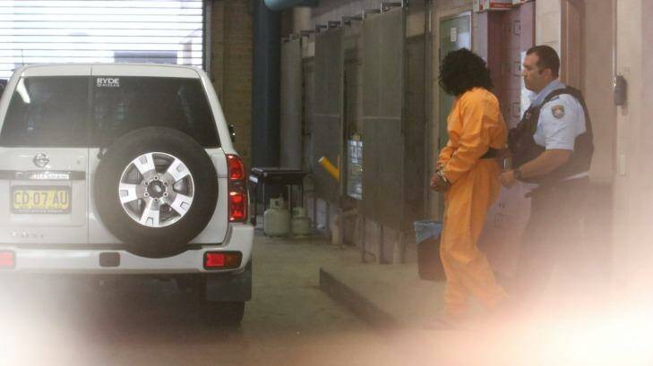 Ahmed Saiyer Naizmand is led out of Burwood Local Court in shackles after his arrest in February.  Photo: Peter Rae