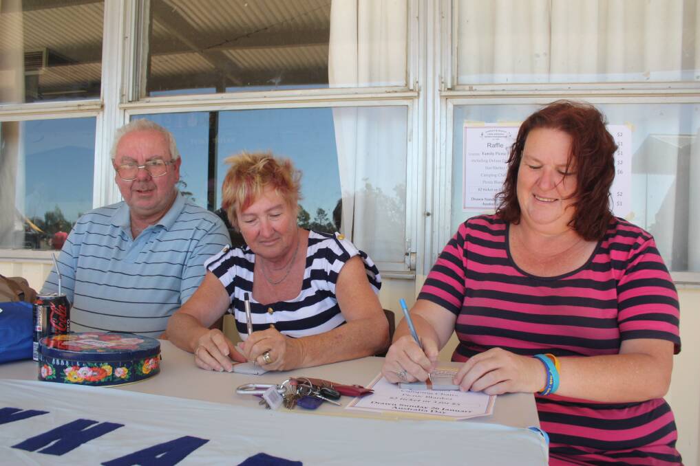 Members of Lockhart Little Athletics club man the raffle stall. Pictured is Gary McVean, Cheryl Power and Tracey Cochrane.