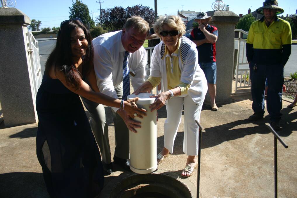 Australia Day ambassador Liz Deep-Jones, Lockhart Shire mayor Peter Yates and Myra Jenkins place the new time capsule in the ground at Walter Day Park.