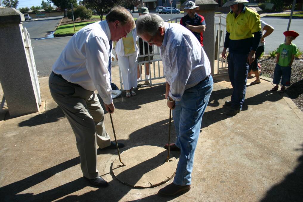 Lockhart Shire mayor Peter Yates and deputy mayor Rodger Schirmer seal the time capsule, to be opened 25 years from now.