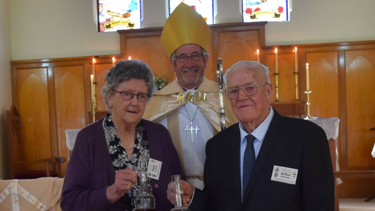 DIVINE ACHIEVEMENT: Bishop Rob Gillion with Phyliss and Arthur Cochrane at St Barnabas' 100th celebration. Picture: Lorri Roden 