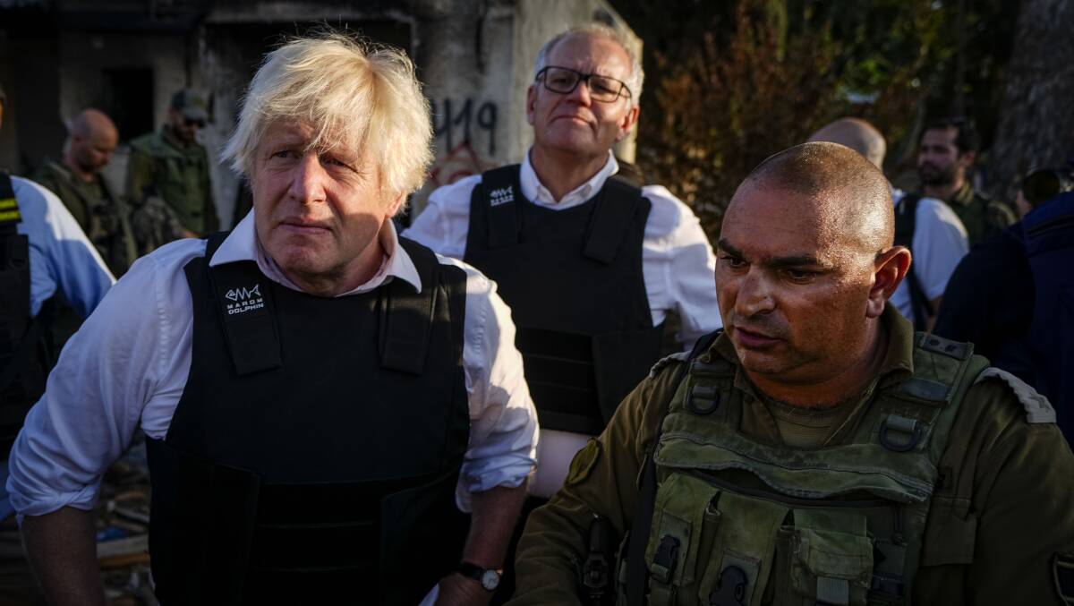 Former UK prime minister Boris Johnson and former Australian prime minister Scott Morrison, background, visit kibbutz Kfar Azza, Israel earlier this month. Picture AAP