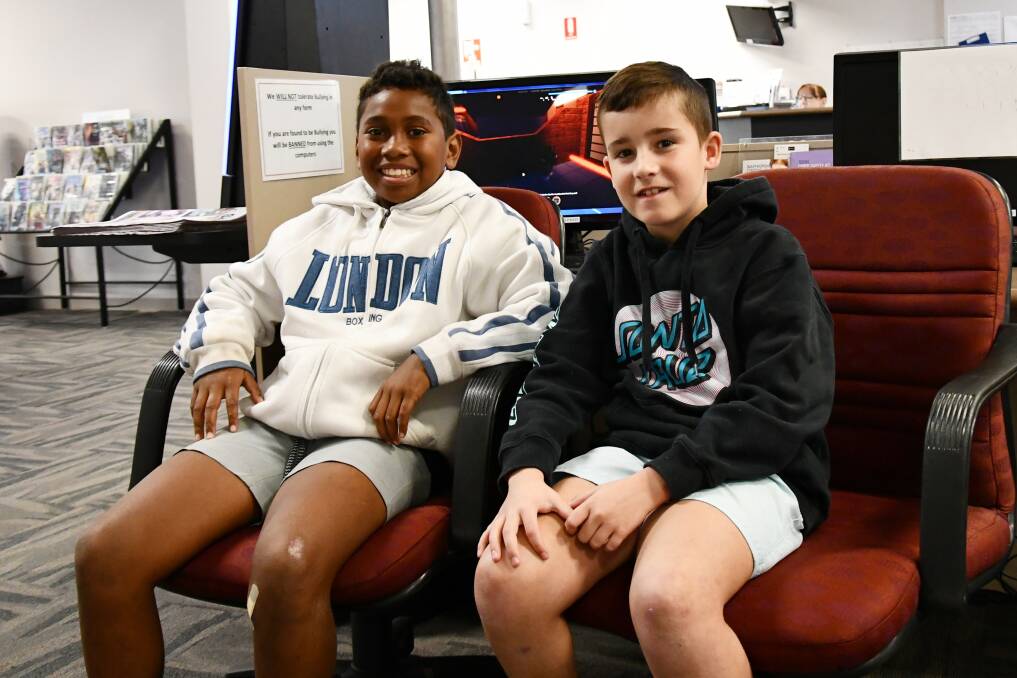 SHORTS, IN THIS WEATHER?: Seveti Bai and Aiden Semmler spend a cold, wet morning at the Culcairn Library.