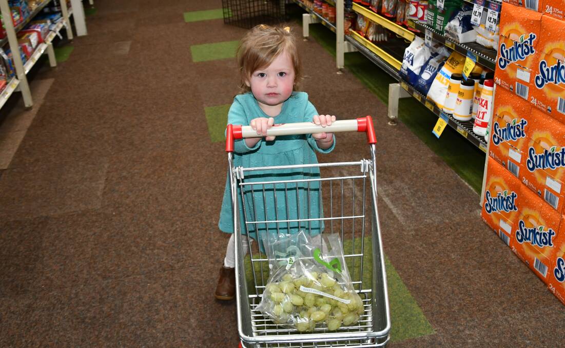 LITTLE HELPER: Olivia Dumesny, 2, picks one of her favourite fruits while helping her mum do the shopping.