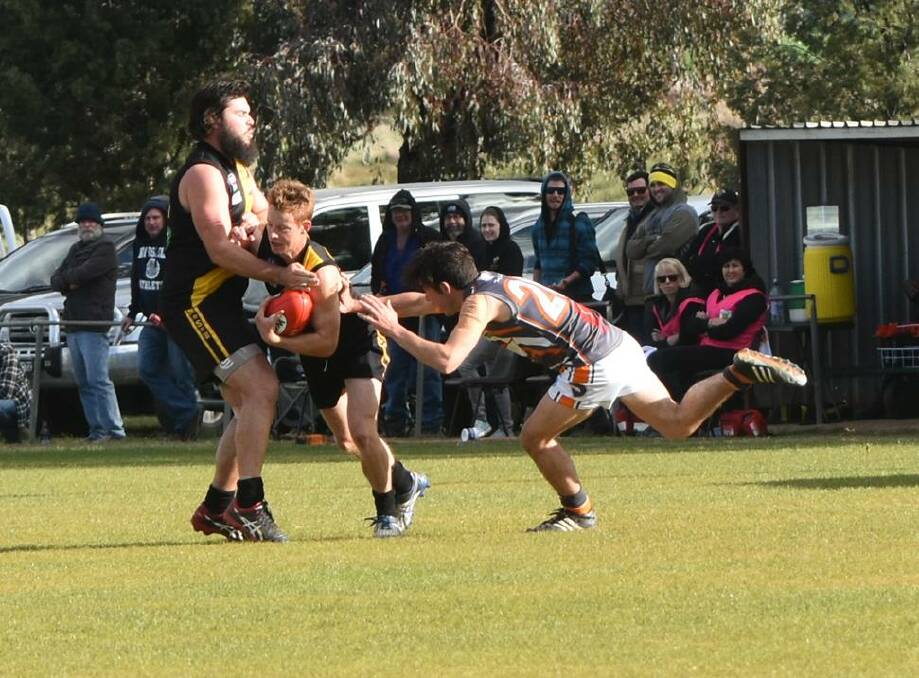 GIANT EFFORT: Osborne players Simon Lane and Sam Rutland are caught up by Rand Walbundrie Walla's Ryan Lavery. Picture: Lorri Roden