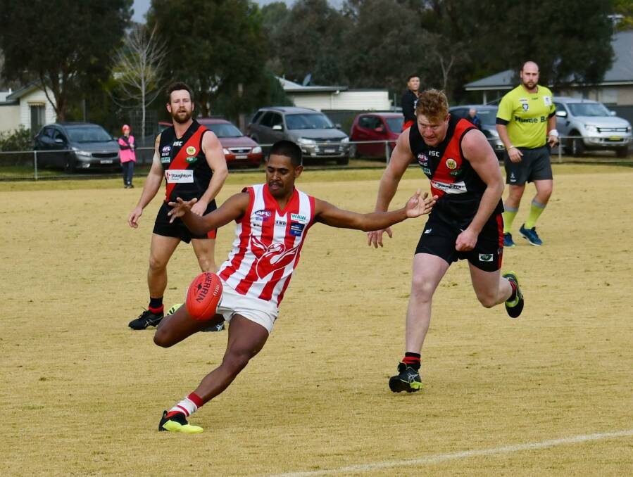 SHIFT: Daniel Cox gets a kick away during Henty's surprise defeat to Howlong. The Swampies' eight-point loss completed a bad day for the visitors. Picture: Lorri Roden