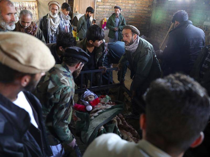 Relatives stand around the dead body of a boy killed by the mortar shell attack in Kabul.