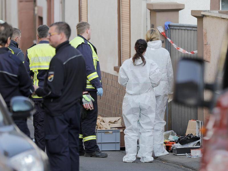 Investigators and fire department crews at the crime scene in Kirchheim, Germany.
