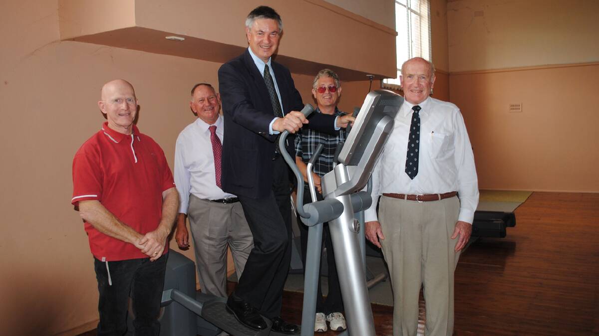  Henty & District Lifestyle Centre (HDLC) committee members Garry Small, Ed Dale, John Ebsworth and committee president John Ross watch as Member for Albury Greg Aplin tries out some of the exercise equipment at the official opening of stage one of HDLC (Photo:  Lorri Roden).