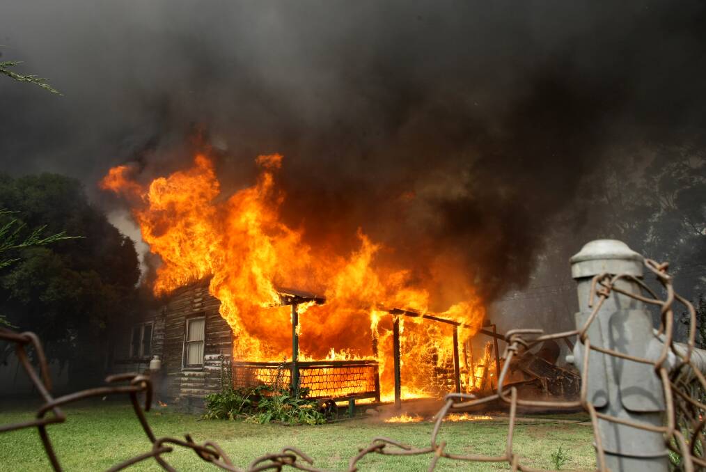 ALIGHT: A house burns during the December 2009 fire. 
