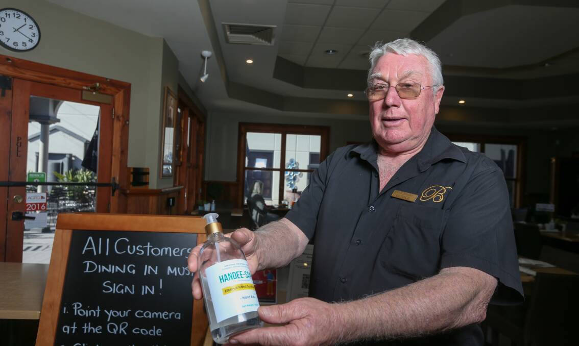 MEASURES ON HAND: Cafe Borellas owner George Benyon with liquid soap that is at the entrance to his eatery along with identity checks in electronic and written form. Photo: TARA TREWHELLA